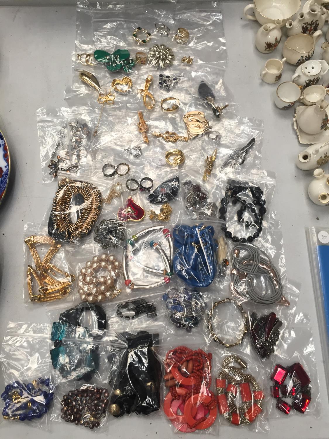 A QUANTITY OF COSTUME JEWELLERY TO INCLUDE BROOCHES, RINGS, NECKLACES, ETC