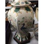 AN ORIENTAL STYLE TABLE LAMP BASE 30CM HIGH AND A LIDDED JAR DECORATED WITH PEACOCKS