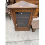 AN OAK GLAZED CORNER CUPBOARD WITH H-BRASS HINGES