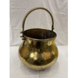 A VERY LARGE BRASS CAULDRON WITH THREE BALL FEET AND A ROPE DESIGN, HANDLE HEIGHT 43CM