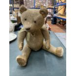 A VINTAGE ARTICULATED TEDDY BEAR WITH HUMP ON BACK - HEIGHT APPROX 44CM