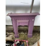 A PURPLE PAINTED CAST IRON FIREPLACE