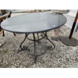 A DECORATIVE WROUGHT IRON BASED ROUND GARDEN PATIO TABLE WITH GRANITE TOP