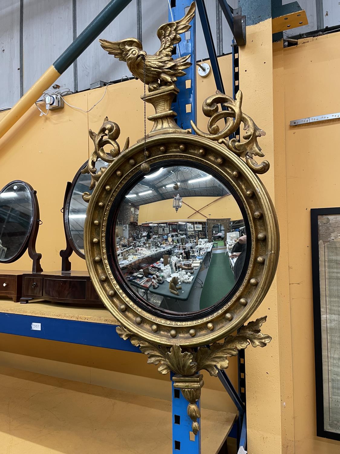 A CIRCULAR REGENCY GILT CONVEX WALL MIRROR 60CM DIAMETER WITH FOLIATE DECORATION TO RIM SURMOUNTED - Image 2 of 4