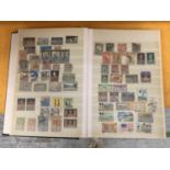 A COLLECTION OF INTERNATIONAL STAMPS IN AN ALBUM