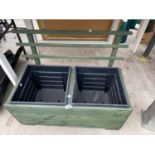 A WOODEN TWO SECTION TROUGH PLANTER WITH TWO PLASTIC INSERTS