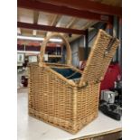 A WICKER PICNIC BASKET FOR TWO WITH BOTTLE HOLDER, PLATE STRAP, ETC
