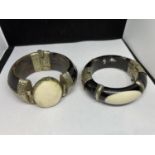 TWO HEAVY EBONY BANGLES WITH BELIEVED SILVER DECORATION