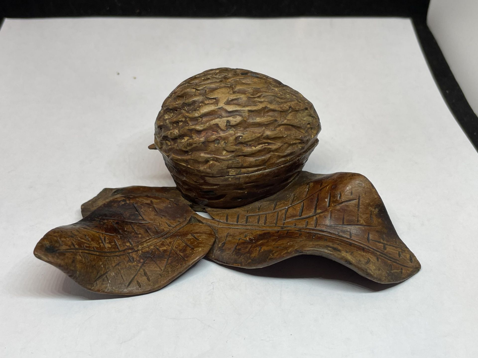 A CARVED WOODEN NUT AND LEAF INKWELL