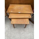 A RETRO TEAK NEST OF THREE TABLES WITH INSET BRASS CORNER STUDS