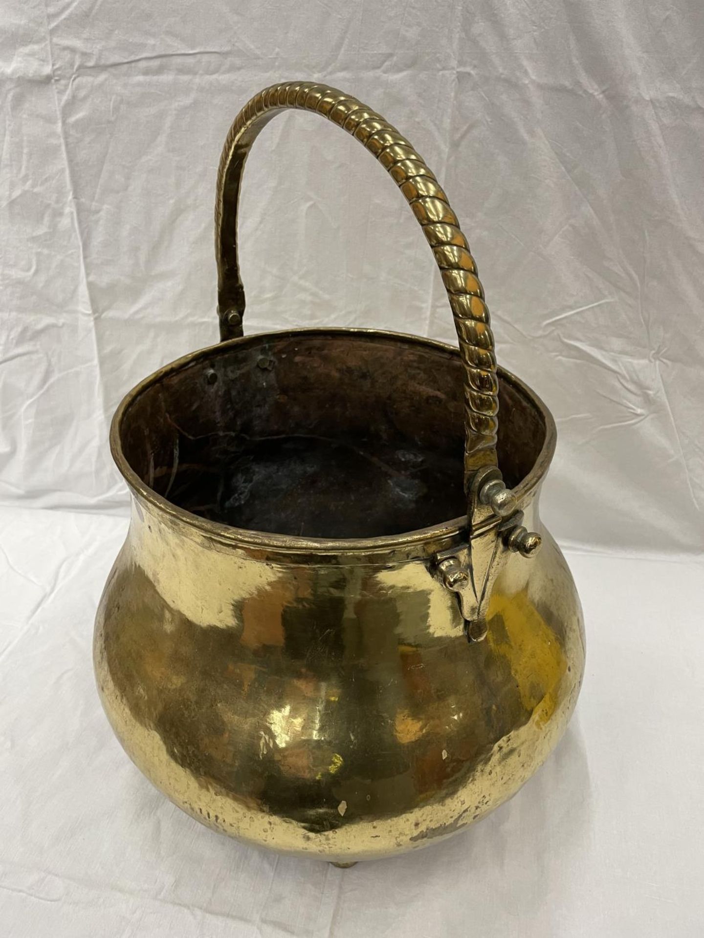 A VERY LARGE BRASS CAULDRON WITH THREE BALL FEET AND A ROPE DESIGN, HANDLE HEIGHT 43CM - Image 3 of 6
