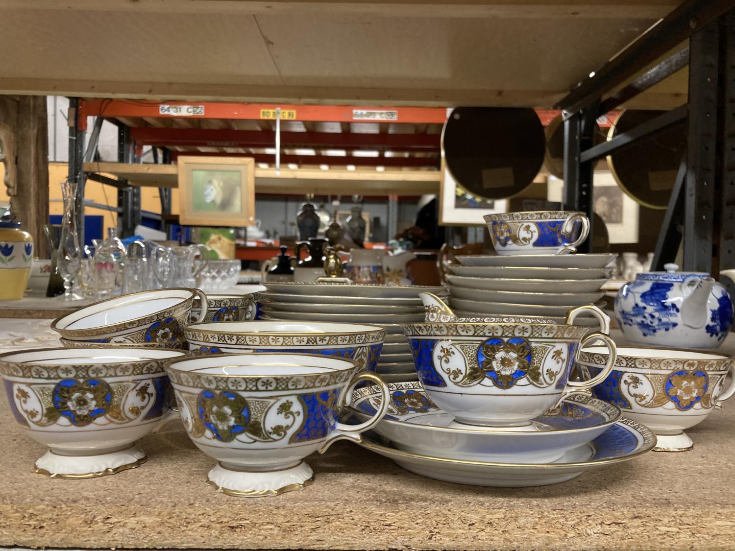 A NORITAKE BLUE AND GOLD COLOURED PART TEASET TO INCLUDE CUPS, SAUCERS, PLATES, CAKE STAND, SUGAR