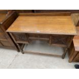 AN EARLY 20TH CENTURY OAK JACOBEAN STYLE KNEEHOLE SIDEBOARD ENCLOSING THREE DRAWERS, 42" WIDE