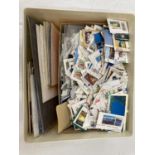 A TUB CONTAINING A FEW COVERS AND CARDS PLUS A QUANTITY OF STAMPS CUT OFF ENVELOPES