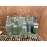 A LARGE ASSORTMENT OF VINTAGE GLASS BOTTLES TO INCLUDE MANY BEARING VINTAGE MAKERS NAMES