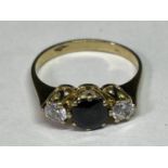 A TESTED TO 9 CARAT GOLD RING WITH CENTRE SAPPHIRE AND A CLEAR STONE EACH SIDE