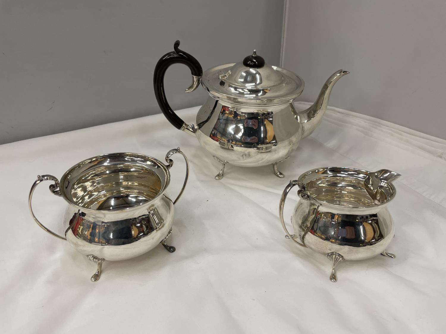 A THREE PIECE HALLMARKED BIRMINGHAM SILVER TEA SET TO INCLUDE A TEAPOT, TWIN HANDLED SUGAR BOWL