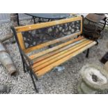 A WOODEN SLATTED GARDEN BENCH WITH CAST ENDS AND FLORAL CAST BACK