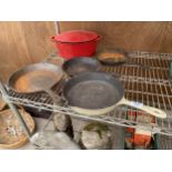 AN ASSORTMENT OF FIVE CAST IRON PANS TO INCLUDE FOUR SKILLETS AND A COOKING POT