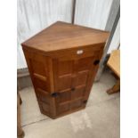 A MID 20TH CENTURY ROBERT 'MOUSEMAN' THOMPSON OAK CORNER CUPBOARD WITH PANELLED DOOR, HAVING CAST