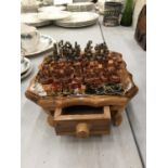 A SMALL CHESS SET WITH FIGURES ON A BOARD WITH A DRAWER FOR STORAGE 21CM X HEIGHT 8CM