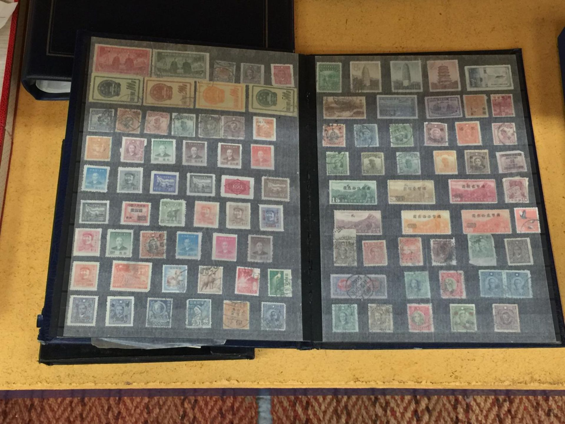 AN ALBUM CONTAINING RARE AND COLLECTABLE MOSTLY ASIAN STAMPS