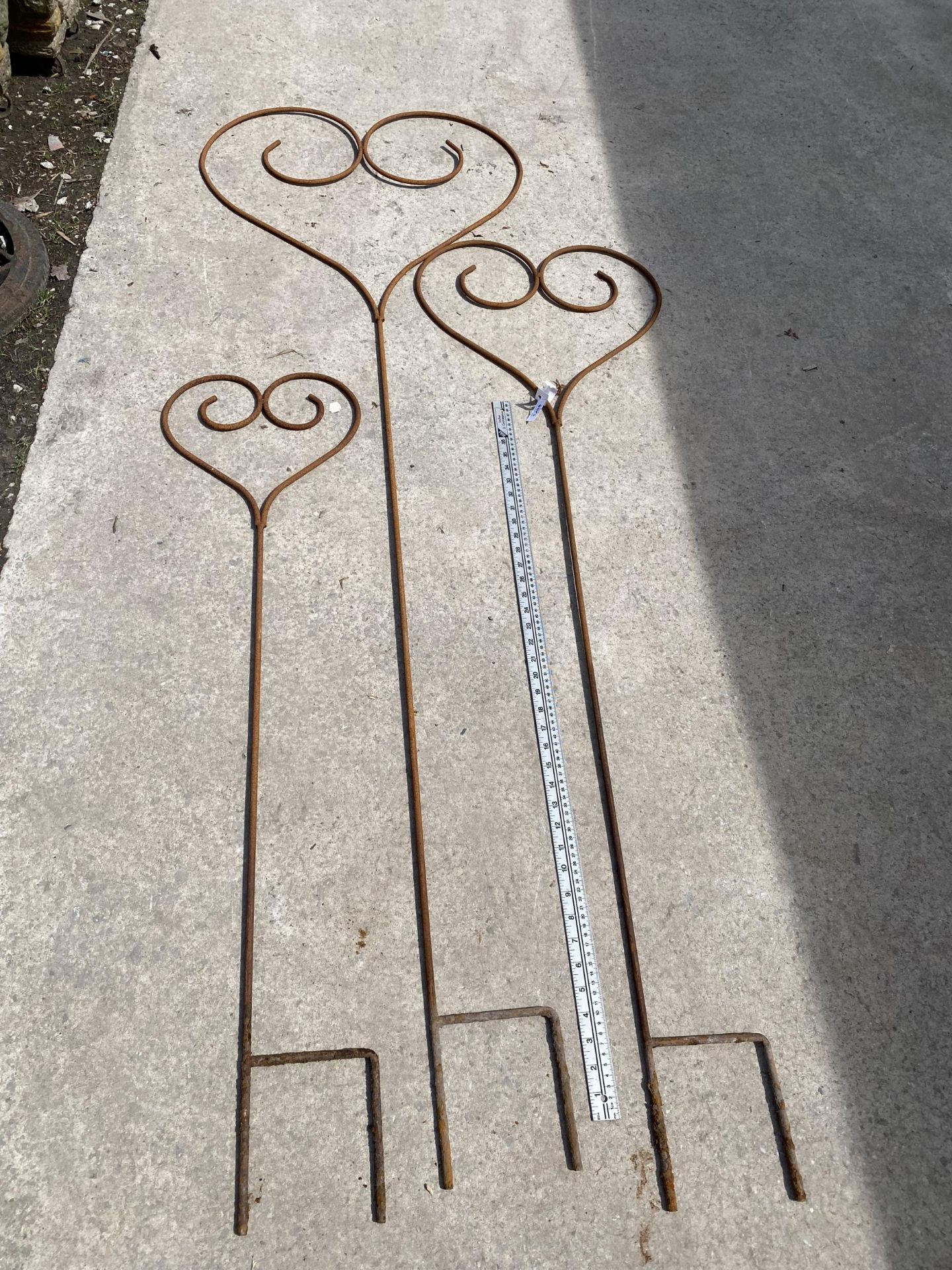 A GRADUATED SET OF THREE WROUGHT IRON HEART SHAPED PLANT SUPPORTS/GARDEN FEATURES