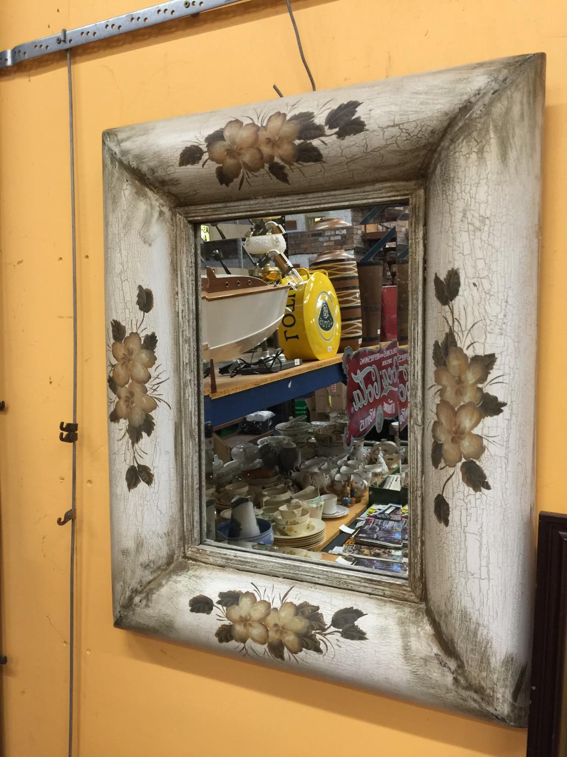 A LARGE BEVELLED GLASS MIRROR WITH WOODEN VINTAGE FRAME DECORATED WITH FLOWERS APPROX 76CM X 63CM