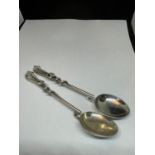 A PAIR OF MARKED 800 SILVER SPOONS WITH A STORK AND SNAKE DESIGN