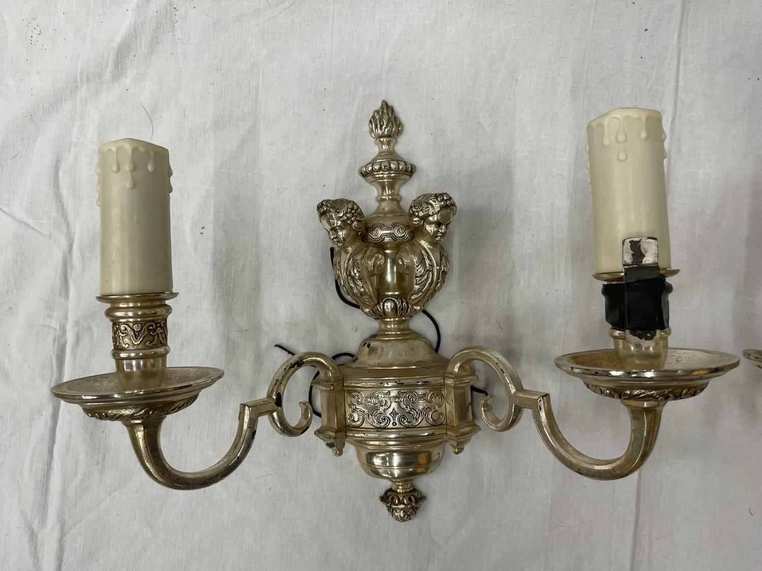 A PAIR OF WHITE METAL DOUBLE WALL LIGHTS WITH CHERUB STYLE DESIGN - Image 2 of 4