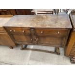 AN EARLY 20TH CENTURY OAK SIDEBOARD ENCLOSING TWO CUPBOARDS AND TWO DRAWERS, ON OPEN BASE WITH SPLAY
