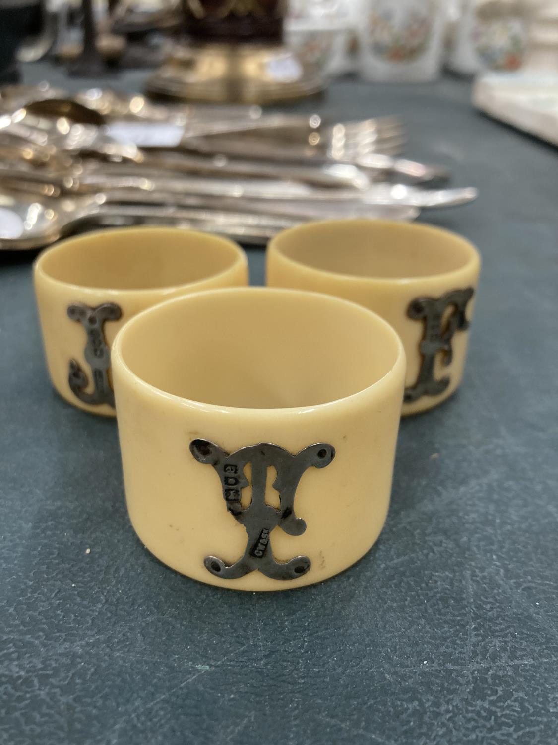 THREE BONE NAPKIN RINGS WITH HALLMARKED LONDON SILVER INITIALS