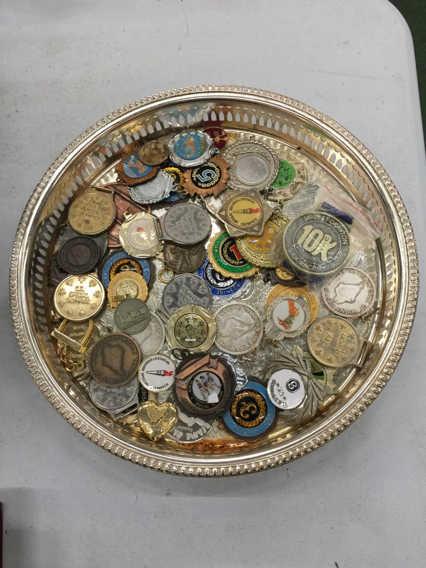 A SILVER PLATED TRAY CONTAINING AN AMOUNT OF 'MEDALS'