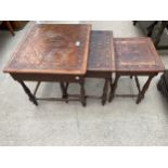 A NEST OF THREE TABLES WITH LEATHER TOPS, WITH EGYPTIAN SCENES