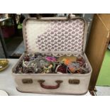 A VINTAGE SUITCASE CONTAINING A LARGE QUANTITY OF COSTUME JEWELLERY, BANGLES, NECKLACES, BEADS,