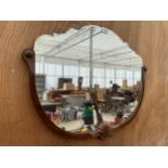 A DECORATIVE MAHOGANY FRAMED WALL MIRROR WITH BEVELED EDGE TOP