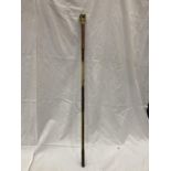 A BRASS AND COPPER WALKING CANE WITH A BUDDAH'S HEAD HANDLE