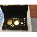 A SET OF BOXED BRASS JEWELLERY SCALES WITH WEIGHTS