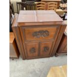 A CHINESE HARDWOOD COCKTAIL CABINET WITH MIRRORED SECTION AND TWO CUPBOARDS TO THE BASE, CARVED