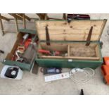 A WOODEN JOINERS CHEST WITH AN ASSORTMENT OF TOOLS TO INCLUDE AN AXE, SECATEURS AND A BATTERY