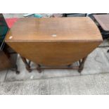 AN EARLY 20TH CENTURY OAK OVAL GATELEG DINING TABLE ON TURNED LEGS, 58X41" OPENED