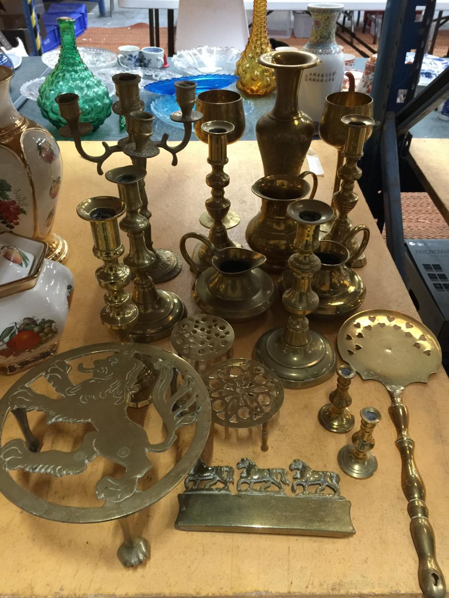 A QUANTITY OF BRASSWARE TO INCLUDE CANDLESTICKS, TRIVETS, GOBLETS, JUGS, VASE, ETC