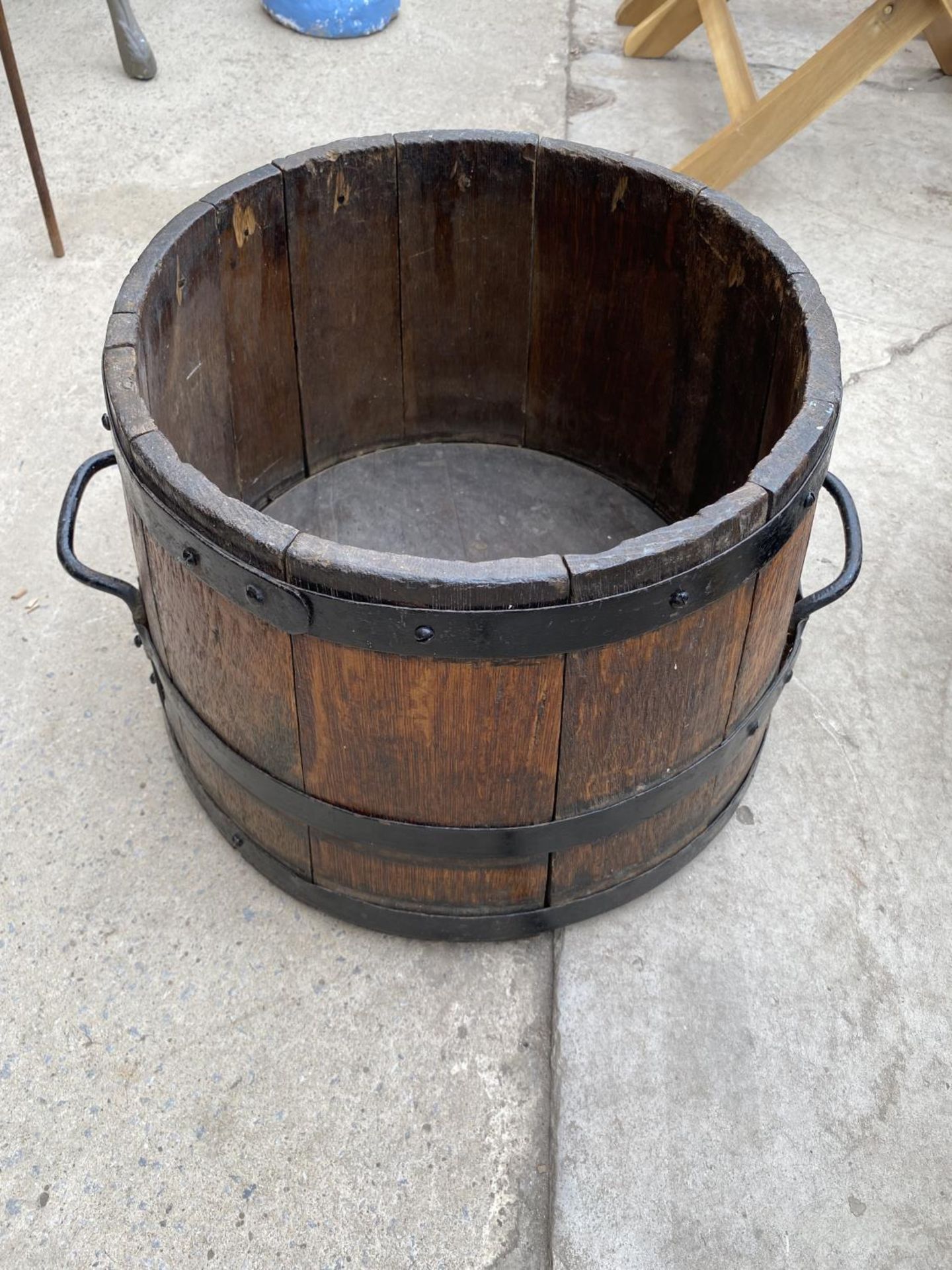 A VINTAGE OAK HALF BARREL WITH METAL BANDING