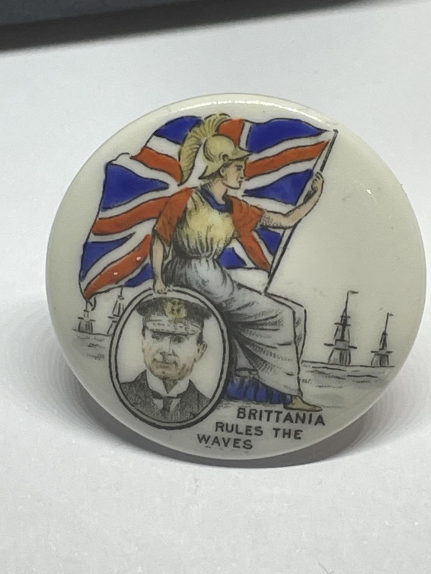 A VICTORIAN CERAMIC NAVAL LAPEL BADGE IN A PRESENTATION BOX