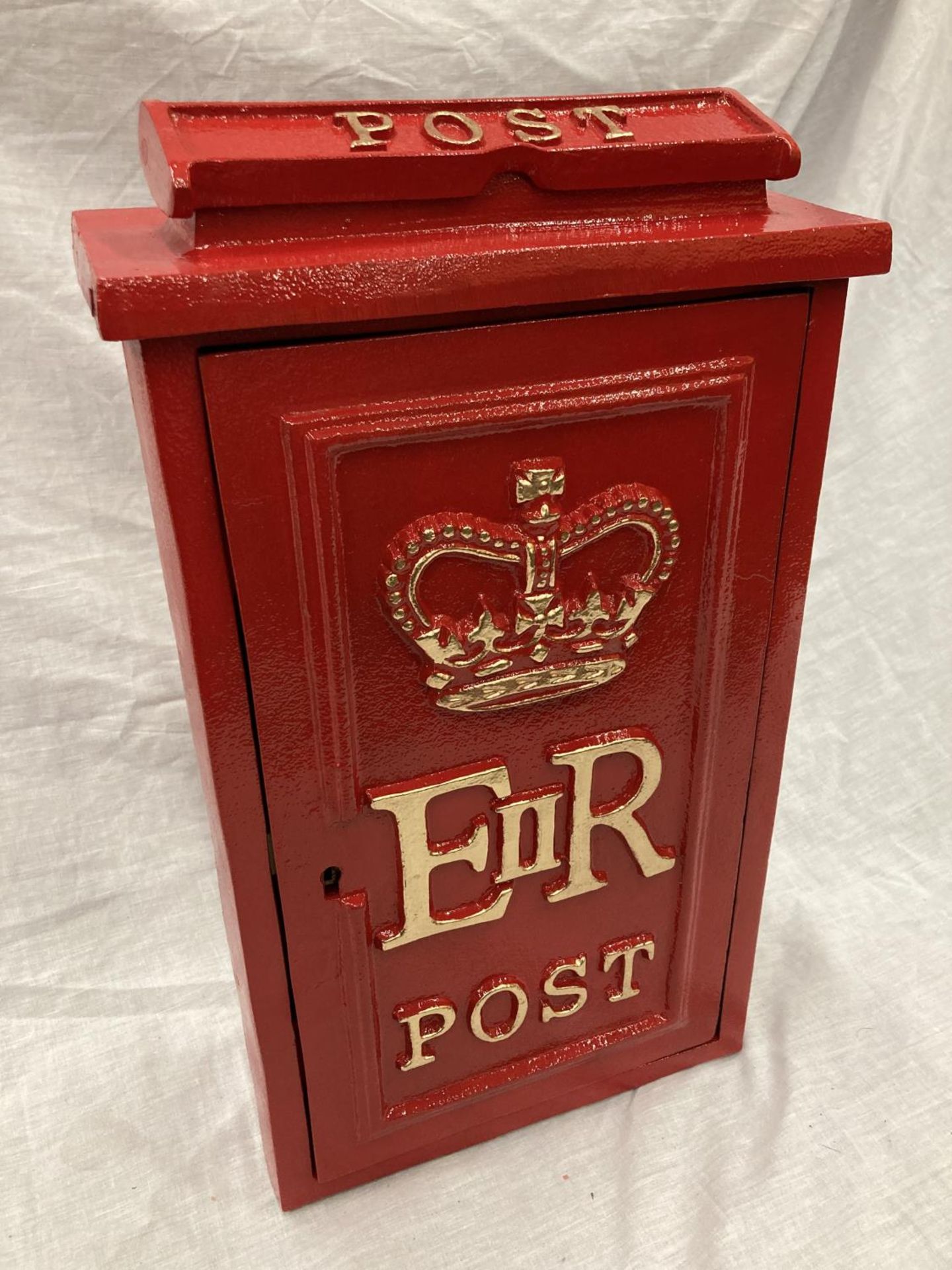 A RED CAST WALL MOUNTED POST BOX WITH KEYS