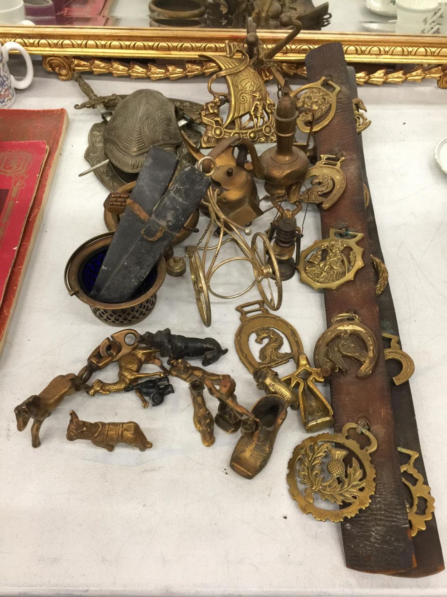 A QUANTITY OF BRASSWARE TO INCLUDE FIGURES, HORSE BRASSES, SHIELD WITH KNIVES, ETC