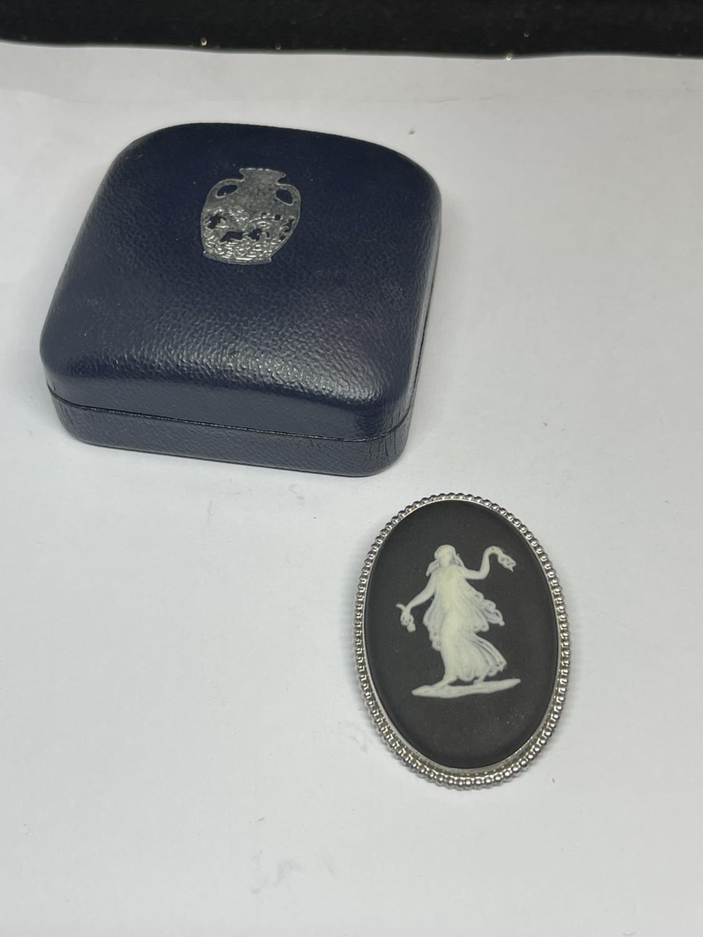 A SILVER MOUNTED BLACK WEDGWOOD JASPERWARE PLAQUE BROOCH IN A WEDGWOOD PRESENTATION BOX