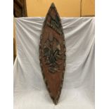 A VINTAGE HAND CARVED AFRICAN 'TRIBAL' SHIELD WITH EMBOSSED ANIMALS AND FISH. LENGTH 139CM, WIDTH