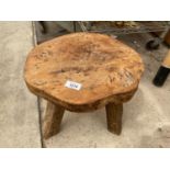 A VINTAGE THREE LEGGED OAK STOOL BEARING THE LABEL 'WANDERWOOD'