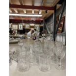 A QUANTITY OF GLASSWARE TO INCLUDE DECANTERS, TANKARDS. WINE GLASSES, CHAMPAGNE FLUTES, ETC